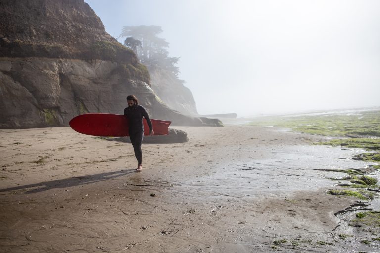 portrait of a Santa Cruz surfer on the beach early morning